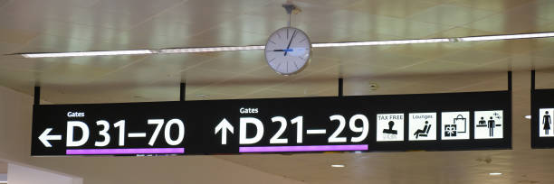 istock Gate numbers, directions, and an analog clock inside an airport terminal. 1175712937