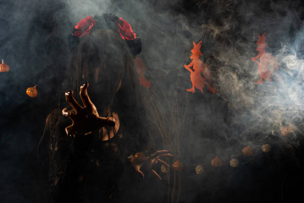 Black Widow veil Ghost girl cover face fresh Wound on face dress come in shadow silhouette as scary and want to revenge in Haunted house, Halloween background with witch and pumpkin garland smoke