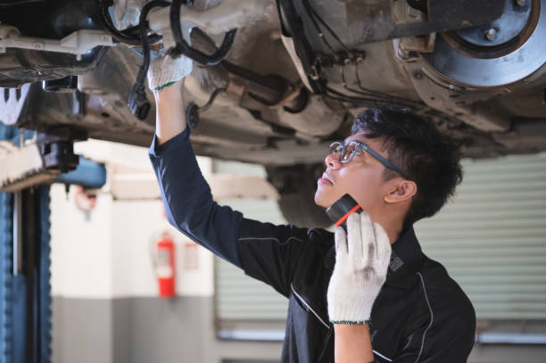 アジアの男性の機械的ホールドと自動車の車のディスクブレーキパッドの摩耗を調べるために輝く懐中電灯。ロードトリップコンセプト前のお客様の安全サスペンション点検サービスメンテ� - scheduled replacement ストックフォトと画像