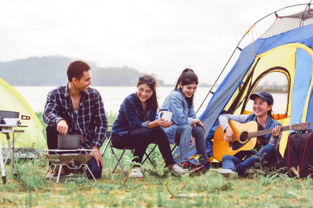 Group of Asian friendship clinking drinking bottle glass for celebrating in private party with mountain and lake view background. People lifestyle travel on vacation concept. Picnic and camping tent Group of Asian friendship clinking drinking bottle glass for celebrating in private party with mountain and lake view background. People lifestyle travel on vacation concept. Picnic and camping tent family bbq beach stock pictures, royalty-free photos & images