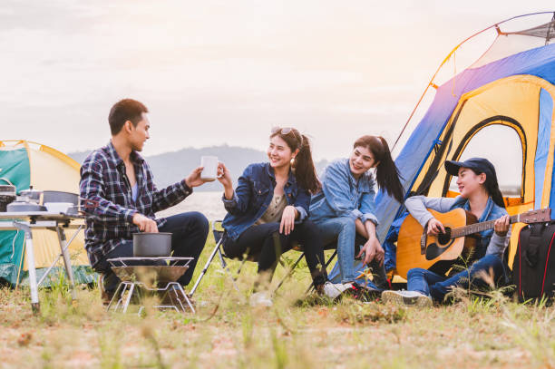 Group of Asian friendship clinking drinking bottle glass for celebrating in private party with mountain and lake view background. People lifestyle travel on vacation concept. Picnic and camping tent Group of Asian friendship clinking drinking bottle glass for celebrating in private party with mountain and lake view background. People lifestyle travel on vacation concept. Picnic and camping tent family bbq beach stock pictures, royalty-free photos & images