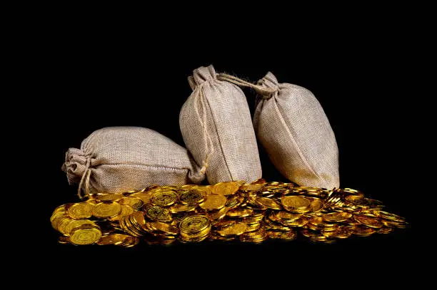Lots of gold coin in treasure sack at black background