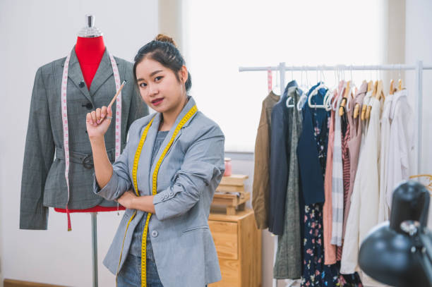 fashion designer stylist in business owner workshop. tailor and sewing concept. portrait of happy casual trendy fashion designer businesswoman in studio looking camera. business job and occupation - mannequin dressmakers model tape measure female imagens e fotografias de stock