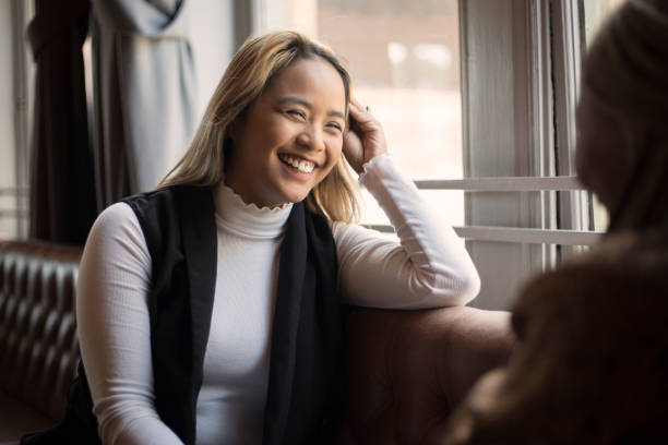 istock Two happy young women talking in a cafe bar 1175717780
