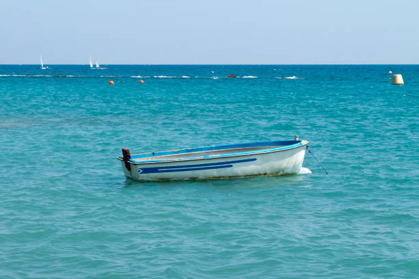 White small wooden boat on the blue sea on a sunny summer day
