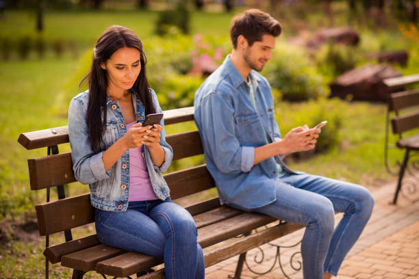 istock Profile side view his he her she nice attractive lovely calm peaceful concentrated best friends wearing denim spending free time leisure sitting on bench chatting service in green wood forest outdoors 1175720160