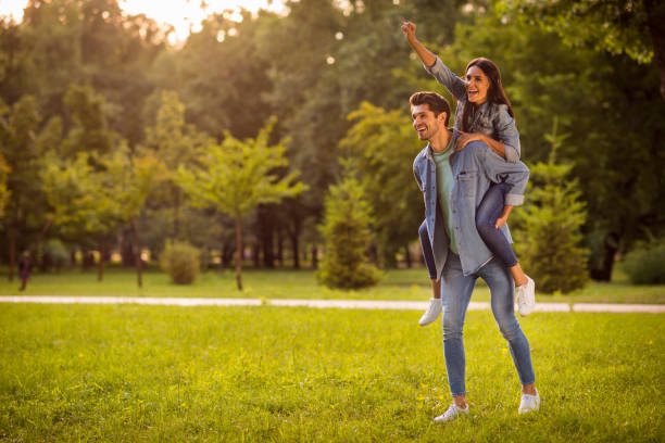 Full size photo of cheerful super hero with brunet hair raising fists piggyback wearing denim jeans jackets blazers outside Full size photo of cheerful super hero with brunet hair raising fists piggyback, wearing denim jeans jackets blazers outside superhero environment women green color stock pictures, royalty-free photos & images