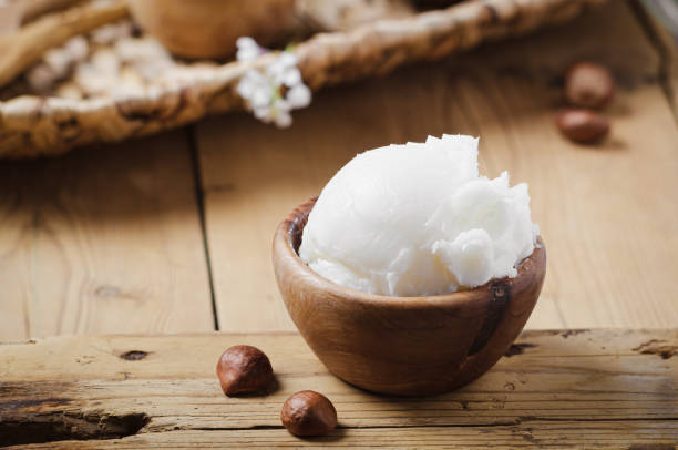 istock Shea butter in wooden bowl with nuts on old rustic table. Free text space. 1175720996