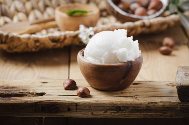 istock Shea butter in wooden bowl with nuts on old rustic table. Free text space. 1175721013
