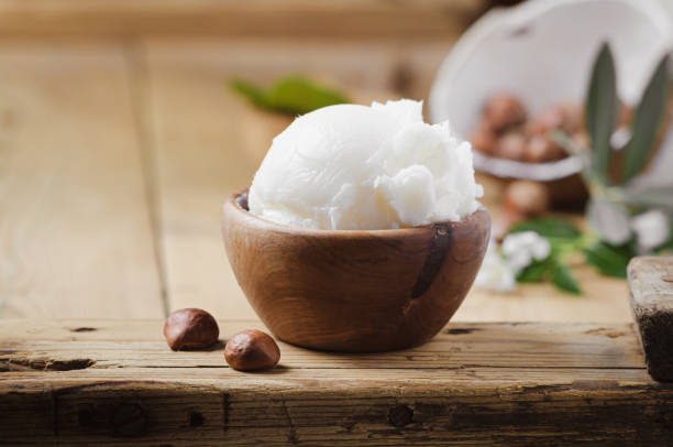 istock Shea butter in wooden bowl with nuts on old rustic table. Free text space. 1175721073
