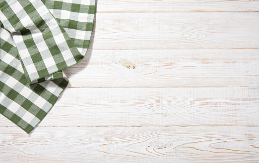 Kitchen towel on empty wooden table on white background. Napkin close up top view mock up for design. .