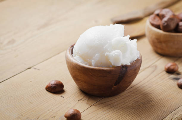 istock Shea butter in wooden bowl with nuts on old rustic table. Free text space. 1175721258