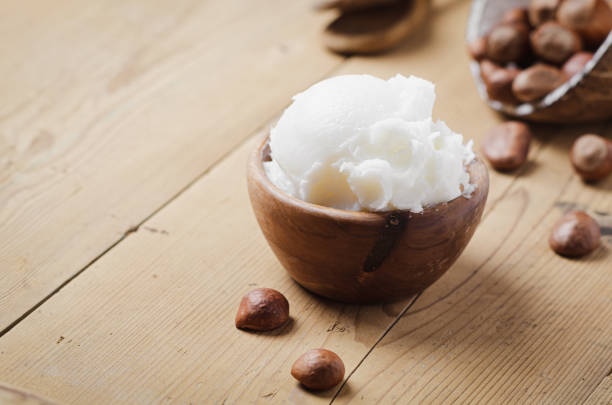 istock Shea butter in wooden bowl with nuts on old rustic table. Free text space. 1175721277