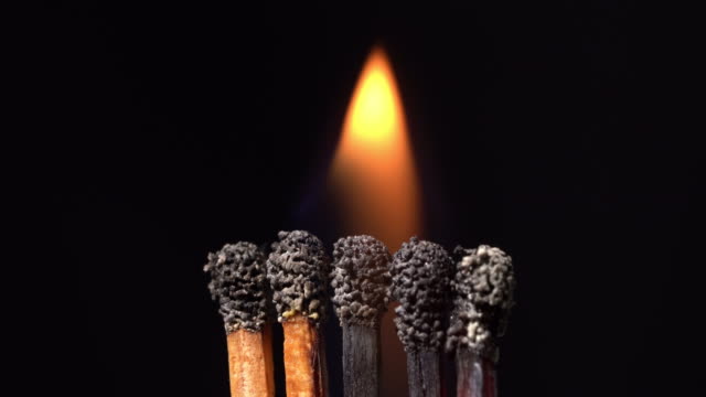 A burning a group of match sticks in black background.