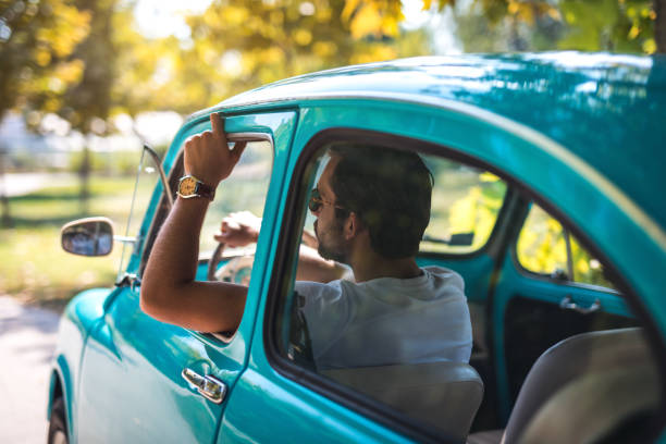 istock Man in vintage car enjoys in ride 1175727351