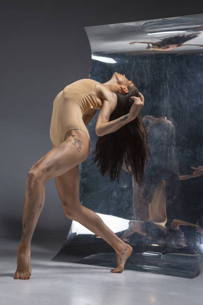 istock Young and stylish modern ballet dancer on grey background 1175729080