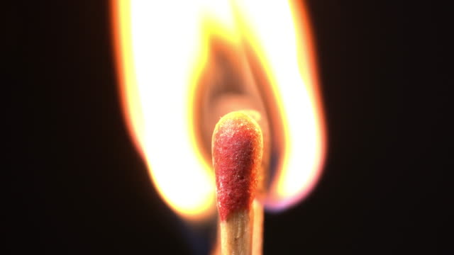 A burning a group of match sticks in black background.