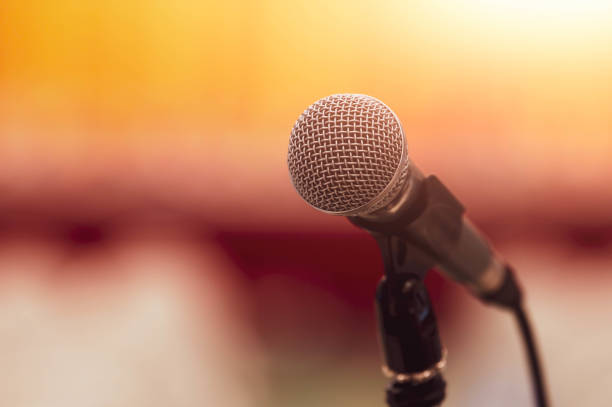 istock Closeup of microphone on abstract blurred background speech in seminar convention hall room and light as guest and conference speaker on podium. Workshop event and Entertainment broadcast concept. 1175729554