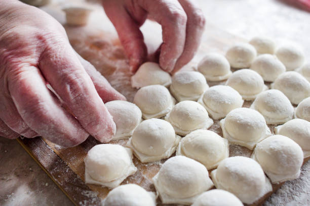 bolinhos maduros da mulher vylazhivaet na tabela, mãos - bread kneading making human hand - fotografias e filmes do acervo