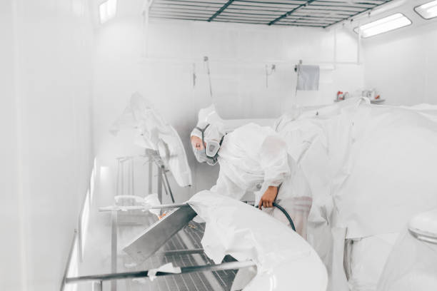 istock Professional painter painting car parts with white paint. 1175740021