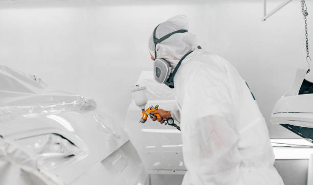 istock Car painter painting car parts in white base paint. 1175740023