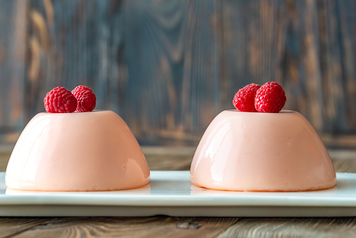 Dessert puddings decorated with fresh raspberries