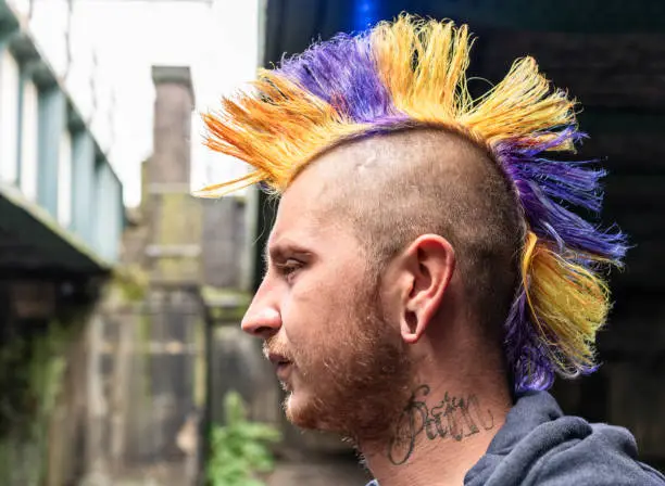 A side view of a punk with a colorful mohawk haircut.
