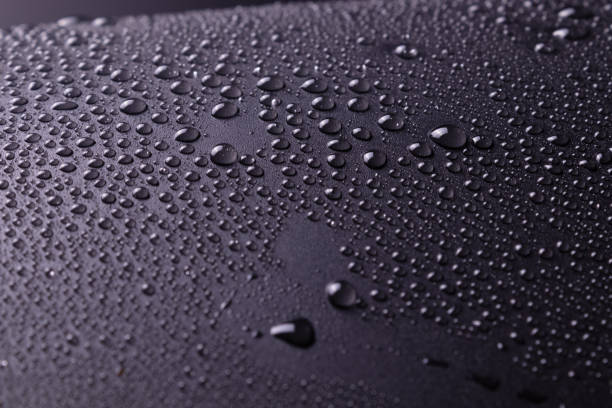 istock large and small drops of water are sprayed onto a dark gray surface with white light and glare on the drops. 1175742990