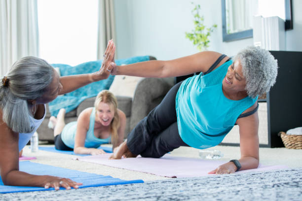 istock Women doing yoga together high five each other 1175744010