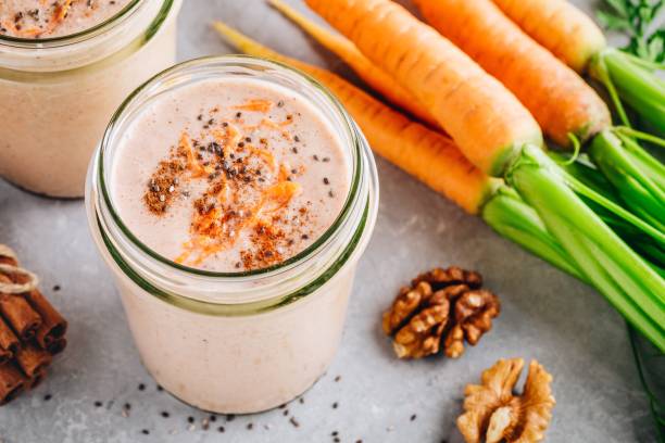 healthy carrot cake smoothie with walnuts and chia seeds in glass jars - orange smoothie imagens e fotografias de stock