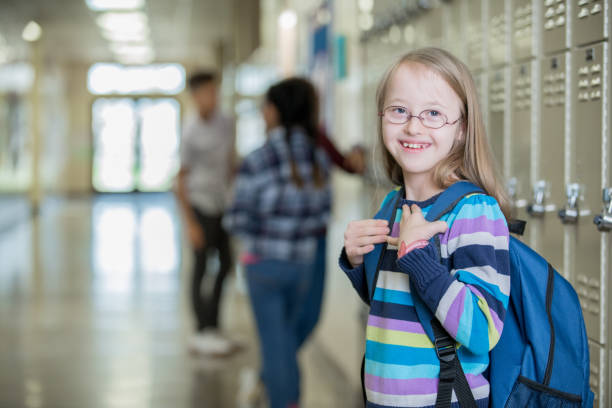 istock Junior high student with Down Syndrome smiles on her way to class 1175745992
