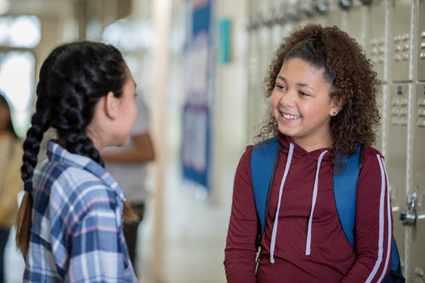 istock Junior high girl students talking by lockers 1175746009