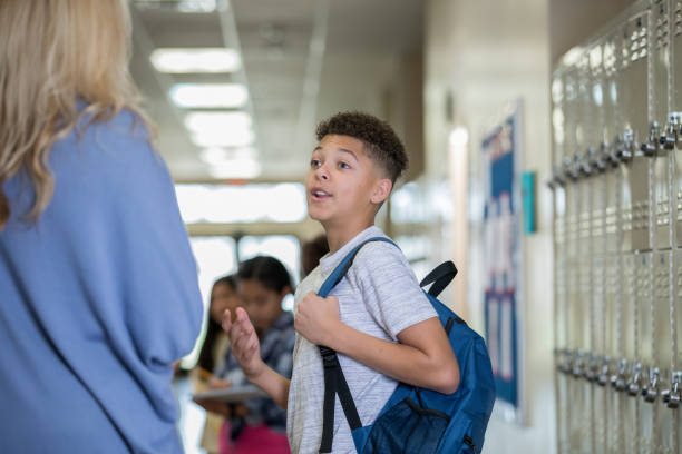 istock Junior high male student talking to principal in hallway 1175746010