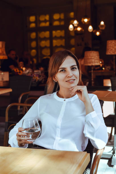 istock Beautiful girl sits in a cafe and drinks water. 1175751005