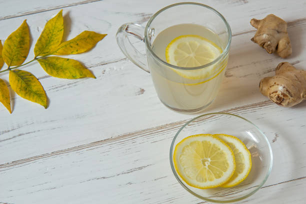 istock Ginger tea with lemon, lemon and leaves on a white table 1175752231