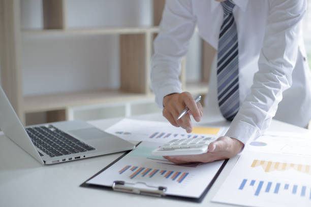 istock Midsection Of Businessman Using Calculator At Table In Office 1175754552