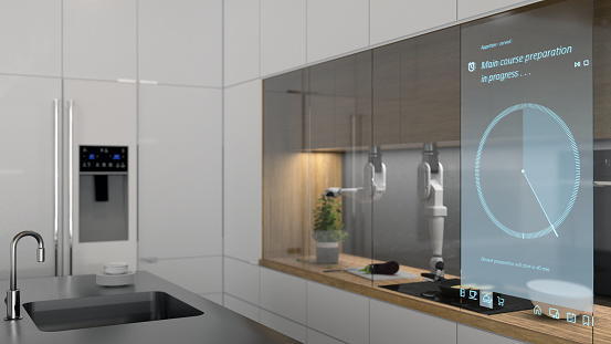 Futuristic kitchen with an interactive screen and robotic arms preparing a meal
