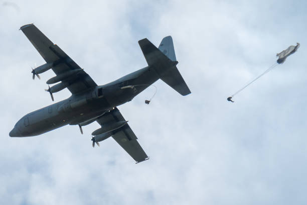 A Hercules airplane drops paratroopers at the occasion of the 75th anniversary of operation Market Garden during World War II This photo was taken at the 75th anniversary of the dropping of para troops in Groesbeek. That happened on September 17, 1944 in the context of Operation Market Garden. In a few days, almost 8,000 American paratroopers were dropped in the immediate surroundings of Groesbeek. In the first days after September 17, the surroundings of Groesbeek and Nijmegen changed into a hellish front area. The bridges of Nijmegen were conquered intact, but had to be defended against all German attacks in the following days and weeks. The Rhine bridge near Arnhem eventually had to be abandoned by the English paratroopers. Large parts of the area south of Nijmegen were freed. This was of great strategic importance for the course of the war; from here the Rhineland offensive, the attack on the German flank, could be deployed. operation market garden stock pictures, royalty-free photos & images
