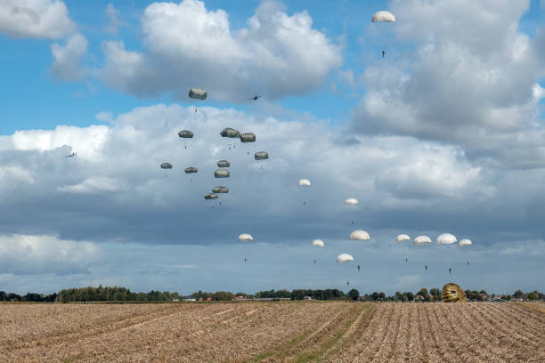 Dropping of paratroopers at the occasion of the 75th anniversary of operation Market Garden during World War II This photo was taken at the 75th anniversary of the dropping of para troops in Groesbeek. That happened on September 17, 1944 in the context of Operation Market Garden. In a few days, almost 8,000 American paratroopers were dropped in the immediate surroundings of Groesbeek. In the first days after September 17, the surroundings of Groesbeek and Nijmegen changed into a hellish front area. The bridges of Nijmegen were conquered intact, but had to be defended against all German attacks in the following days and weeks. The Rhine bridge near Arnhem eventually had to be abandoned by the English paratroopers. Large parts of the area south of Nijmegen were freed. This was of great strategic importance for the course of the war; from here the Rhineland offensive, the attack on the German flank, could be deployed. operation market garden stock pictures, royalty-free photos & images