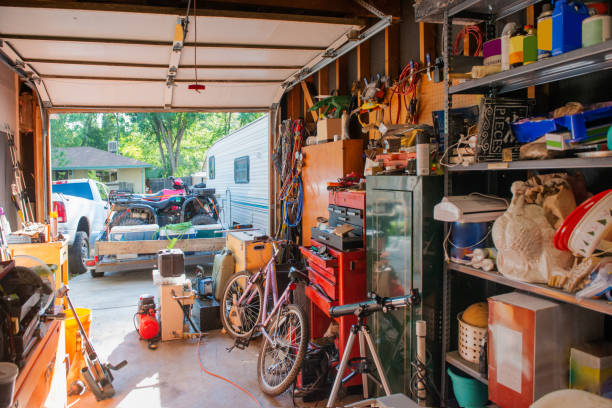 Cluttered Garage Home Storage Room in Denver Colorado This photograph is of a garage lined with shelves full of things stored at home including, tools, cleaning supplies, holiday decorations and sporting equipment. The garage door is open. cluttered stock pictures, royalty-free photos & images