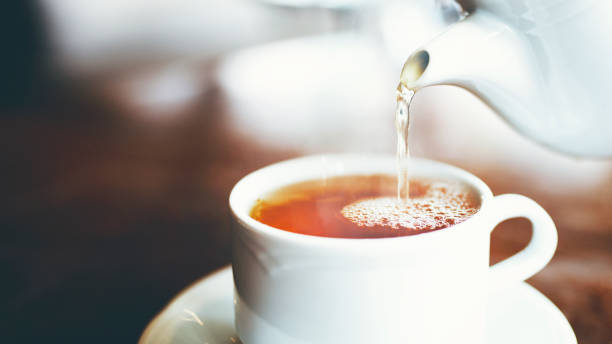 wylewanie filiżanki herbaty - afternoon tea tea women table zdjęcia i obrazy z banku zdjęć