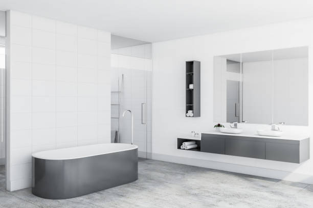istock Corner of white tile bathroom, tub and sinks 1175763684