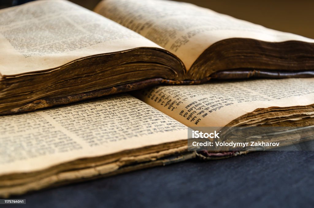 Jewish Bible. An open old Jewish books. Opened scripture pages. Selective focus. Closeup of hebrew text Jewish Bible. An open old Jewish books. Opened scripture pages. Selective focus. Close-up of hebrew text Language Stock Photo