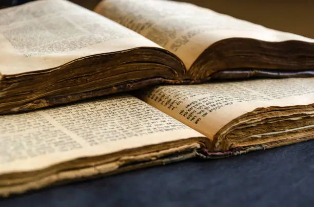 Jewish Bible. An open old Jewish books. Opened scripture pages. Selective focus. Close-up of hebrew text