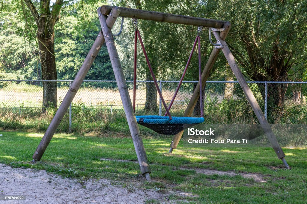 Children Playground With A Rope Round Swing With Wooden Poles Surrounded By  Green Vegetation Stock Photo - Download Image Now - iStock