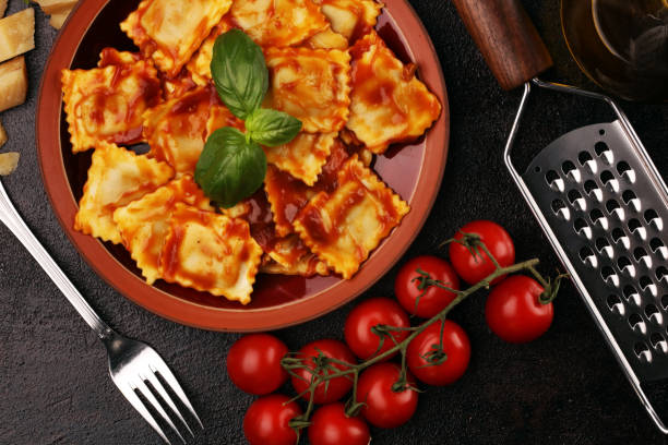 istock Ravioli with tomato sauce garnished with parmesan cheese and basil on rustic table 1175766331