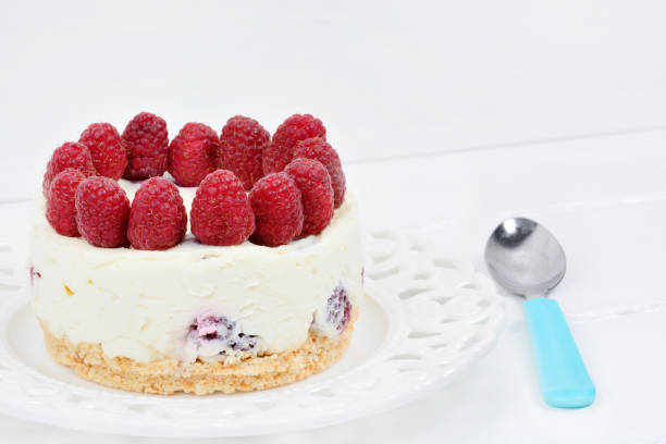 istock Mini cheesecake with white chocolate and raspberries on a wood table 1175768451