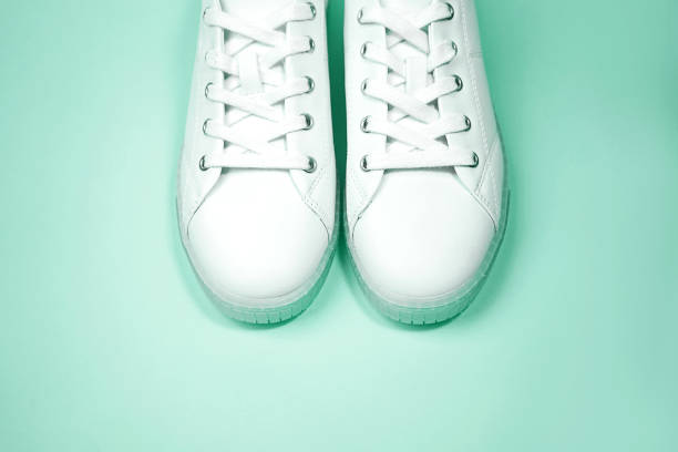 istock White sneakers are lying on a pastel neo mint background. 1175769473