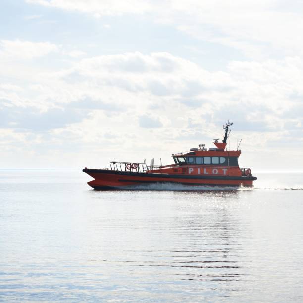 Red pilot ship sailing in still sea water on a sunny day