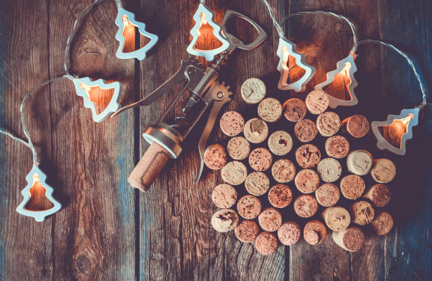 나무 테이블에 와인 코르크, 코르크 나사와 크리스마스 화환 - cork wine corkscrew old 뉴스 사진 이미지